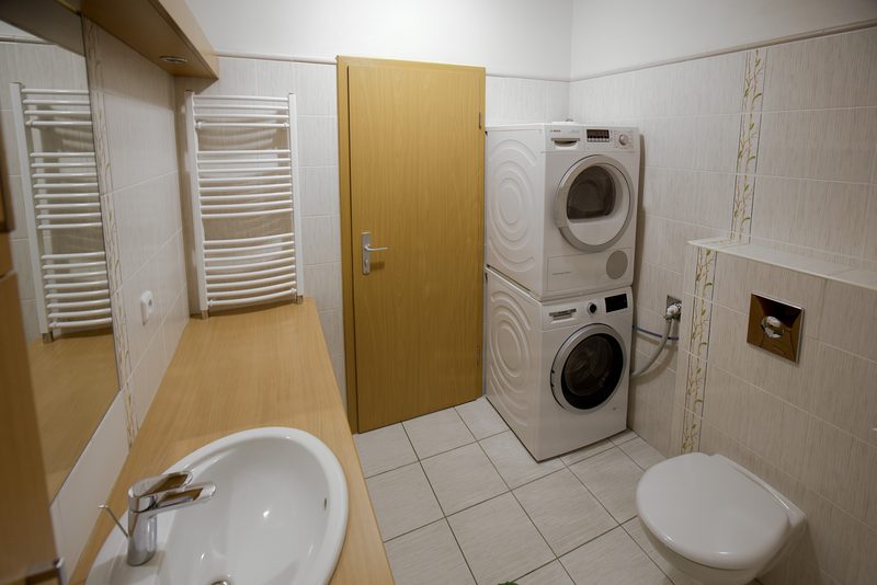 Část koupelny s WC, umyvadlem, pračkou a sušičkou